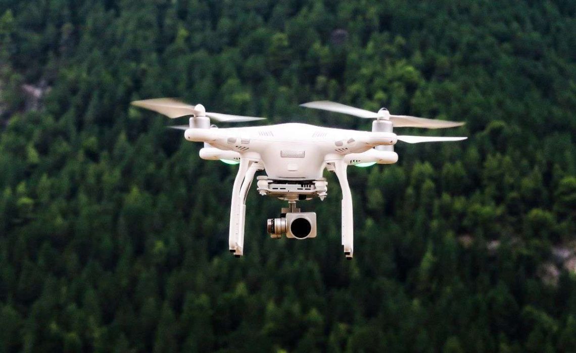 Drone flies near a forest in Greece. Photo by Jason Blackeye